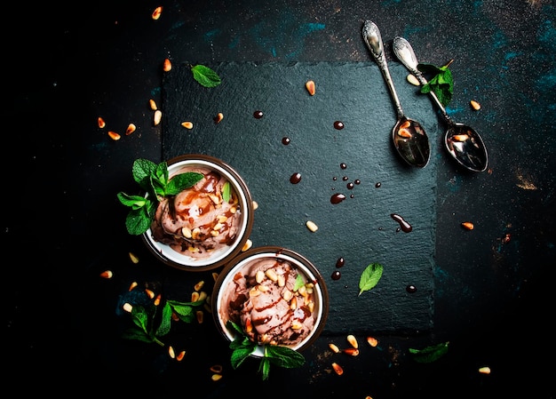 Chocolate ice cream with nuts dark food background top view