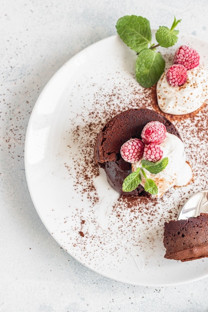 Chocolate lava cake with cream, raspberries and mint