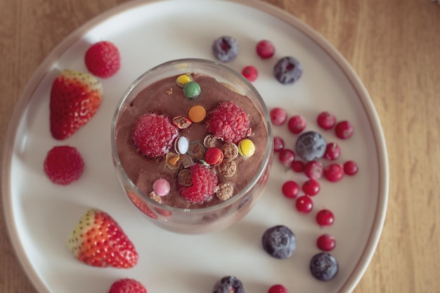 Chocolate mousse with raspberries and strawberries in a glass sweet dessert