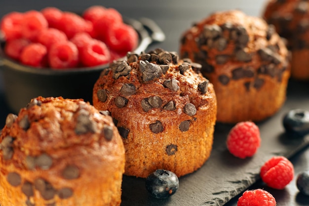 Chocolate muffin with berries Appetizing cupcakes on a dark background