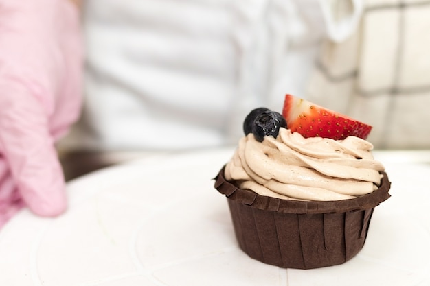 Chocolate muffin with cream and berries