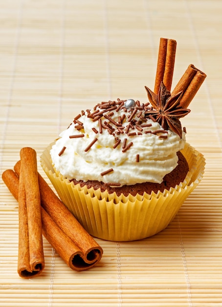 Chocolate muffin with whipped cream chocolate sprinkles and spices