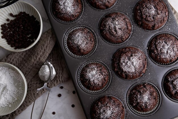 Photo chocolate muffins with chocolate chips in a muffin pan close up