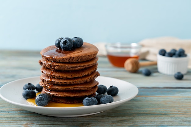 chocolate pancake stack with blueberry and honey on plate