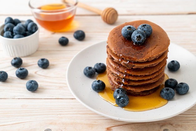 chocolate pancake stack with blueberry and honey on plate