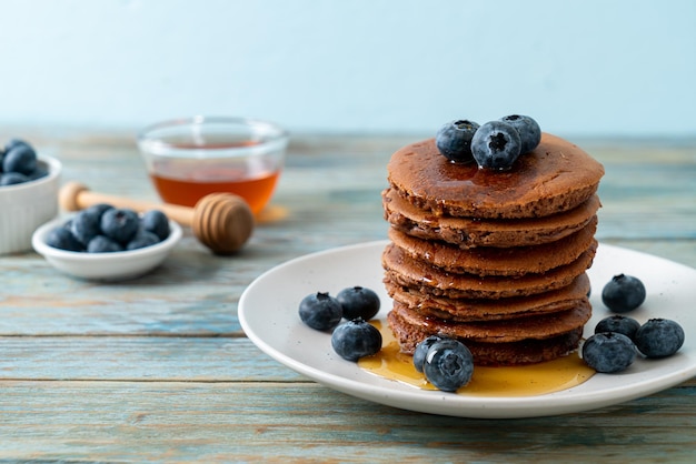 Chocolate pancake stack with blueberry and honey