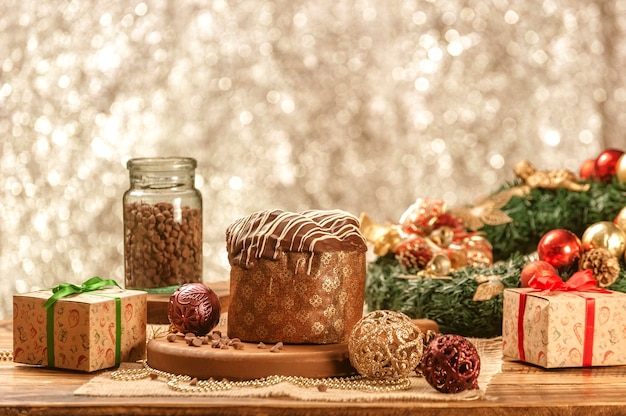 Chocolate panettone  on wooden table with christmas ornaments