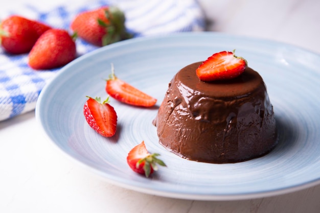 Chocolate panna cotta with strawberry pieces. Italian recipe.