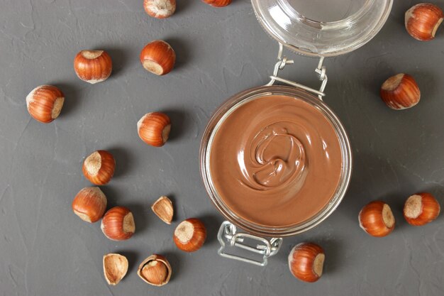 Chocolate paste in a glass jar on a colored background