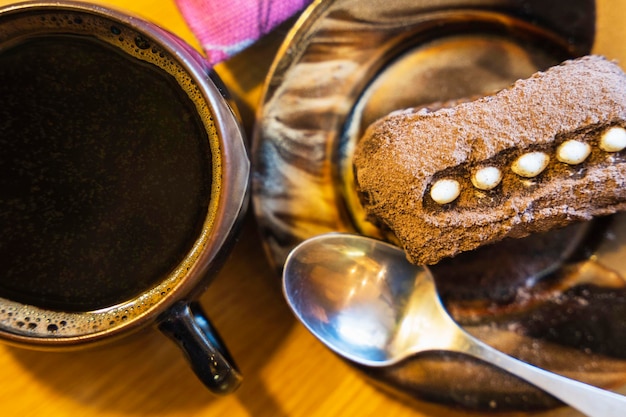 Chocolate rum cake and a cup of coffee  Dessert decorated with cream and cocoa coffee break cafe