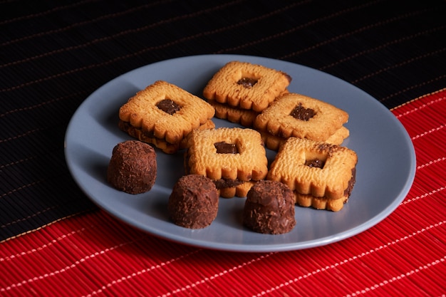 Chocolate sand chip cookies stacked up on a plate, ready to be served on blue plate