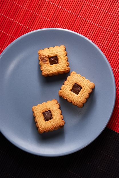 Chocolate sand chip cookies stacked up on a plate, ready to be served on blue plate