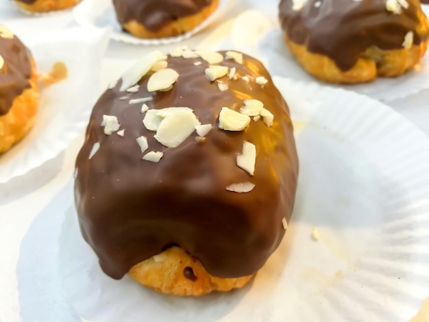 Chocolate Scone with almond parts on bakery paper in the bakery shop