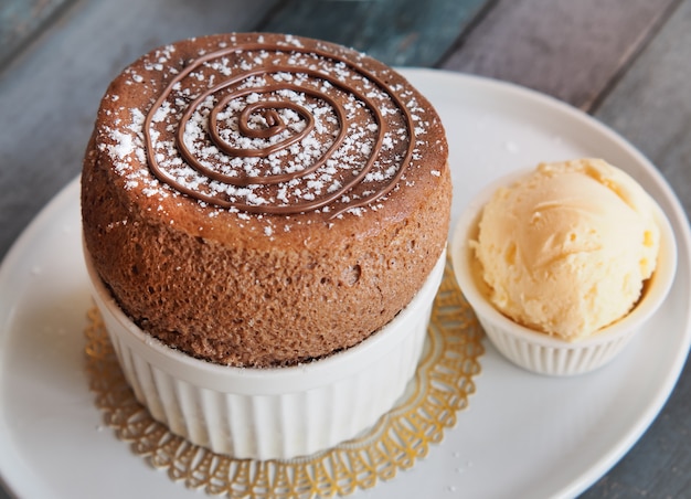 Chocolate Souffle with vanilla ice cream on white plate . French traditional dessert.