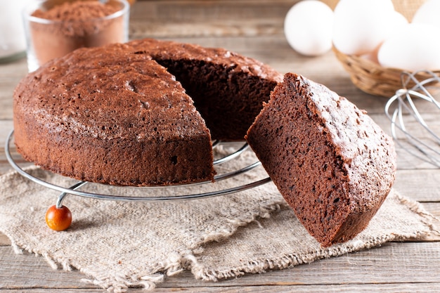 Chocolate sponge cake on a wooden table with ingredients