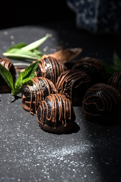 Chocolate truffles. Dark chocolate candies with cocoa on a dark background .