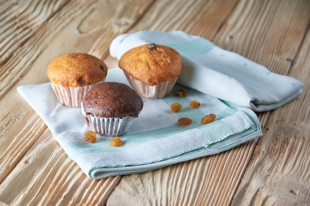 Chocolate and vanilla muffins with nuts on wooden surface, selective focus