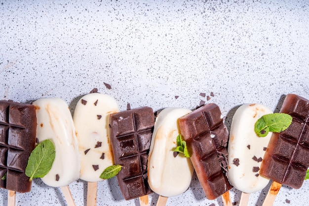 Chocolate and vanilla popsicles Classic dark brown cocoa and milk cream ice cream lolly pops Stack of various icecream lollies flatlay top view copy space