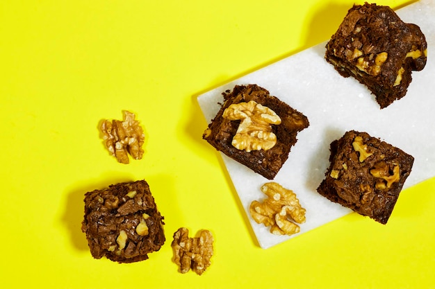 chocolate walnuts brownie cake on yellow background