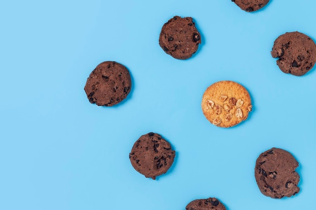 Chocolate and white cookies on a blue background Top view flat lay