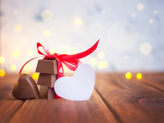 Chocolate with ribbon and heart on St. Valentine's day and bokeh.