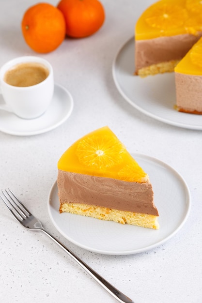 Chocolateorange mousse cake with biscuit base jelly and orange circles Piece of homemade cheesecake and a cup of coffee Traditional holiday dessert Selective focus closeup