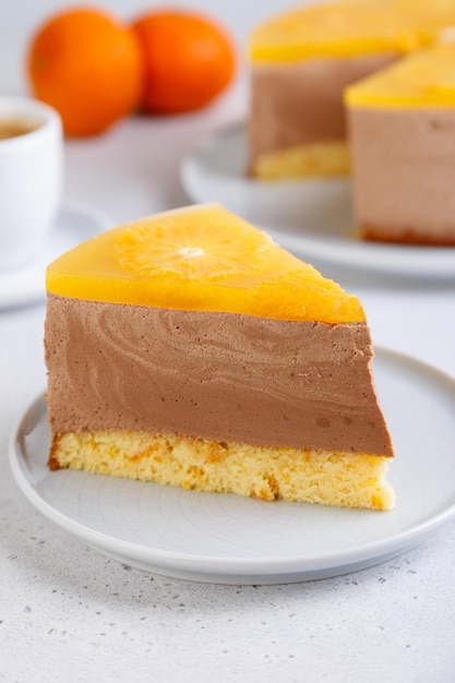 Chocolateorange mousse cake with biscuit base jelly and orange circles Piece of homemade cheesecake and a cup of coffee Traditional holiday dessert Selective focus closeup