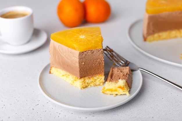 Chocolateorange mousse cake with biscuit base jelly and orange circles Piece of homemade cheesecake and a cup of coffee Traditional holiday dessert Selective focus closeup