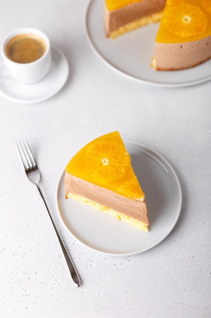 Chocolateorange mousse cake with biscuit base jelly and orange circles Piece of homemade cheesecake and a cup of coffee Traditional holiday dessert Selective focus closeup