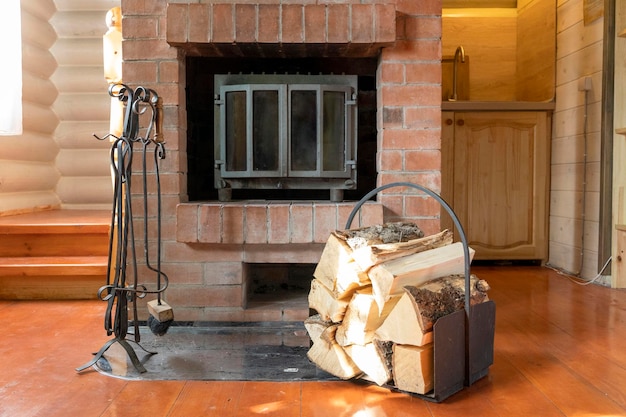 Chopped firewood stacked in woodpile against background of fireplace