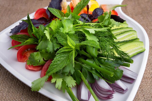 Chopped fresh vegetables with herbs on a white plate