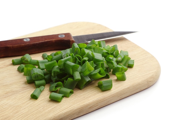 Chopped spring onions on a wooden chopping board