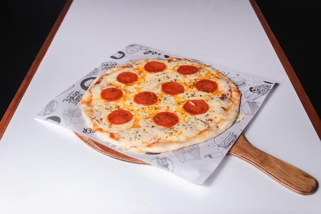 Chopped view of a pepperoni pizza on a white table