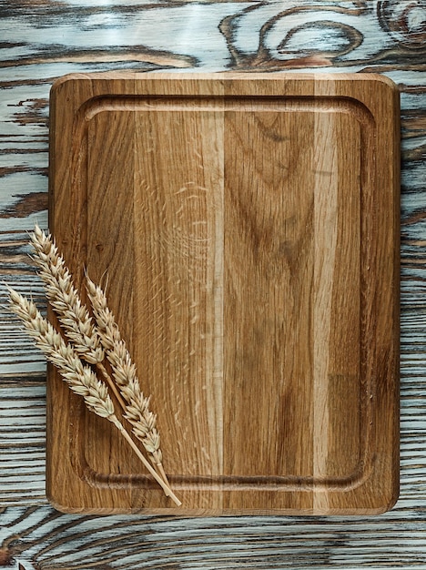 Chopping board wheat ears on vintage wooden surface