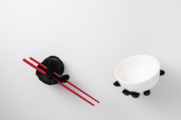 Chopstick and bowl hold with glove on white background