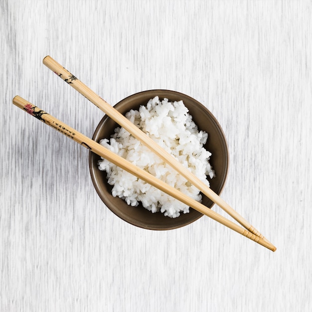 Chopsticks on bowl with rice