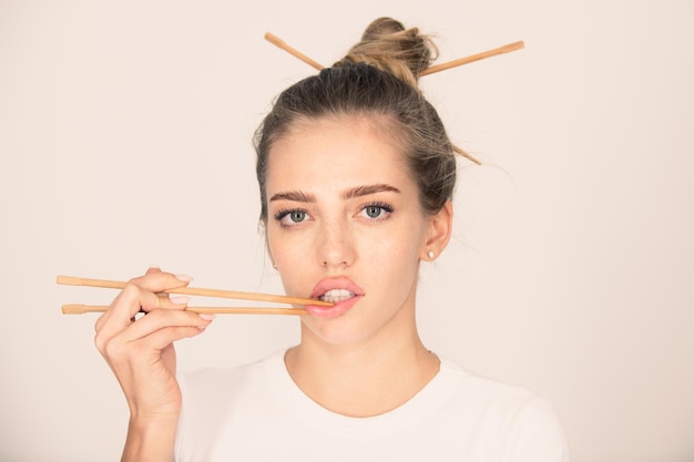 Chopsticks near sexy lips mouth sexy woman touch sensual lips with chopsticks sushi advertising