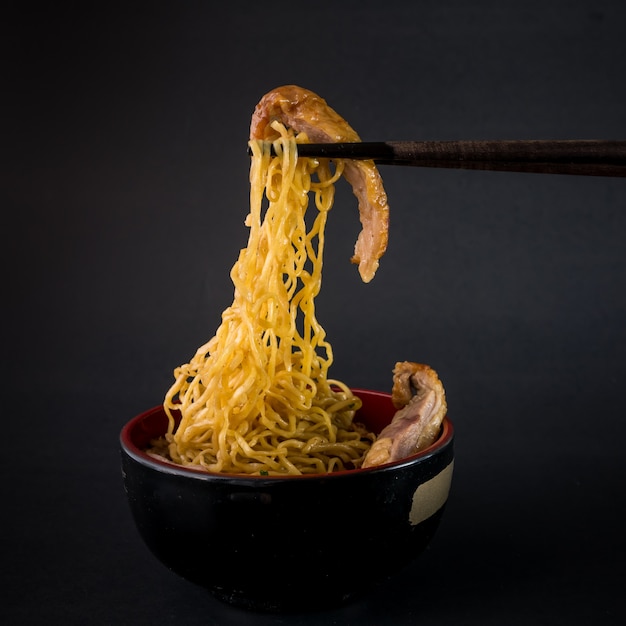 chopsticks and Roast duck noodle on black background,