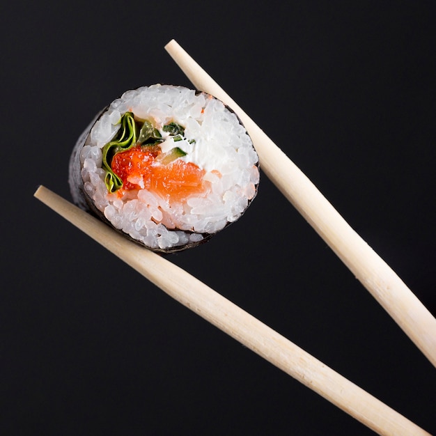 Chopsticks with sushi roll