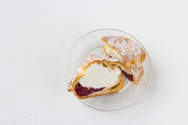 Choux Bun with whipped cream and sugar powder on top Choux pastry dessert French cream puff