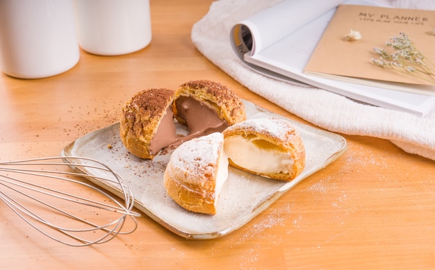 Choux cream placed on a plate, Brown wooden background.