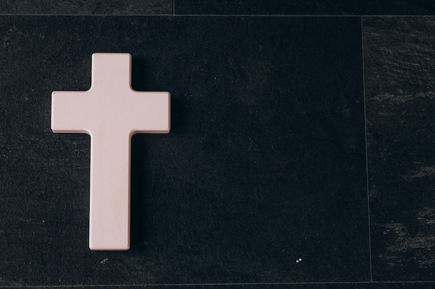 Christian cross on a textured black background Religion concept Pink cross