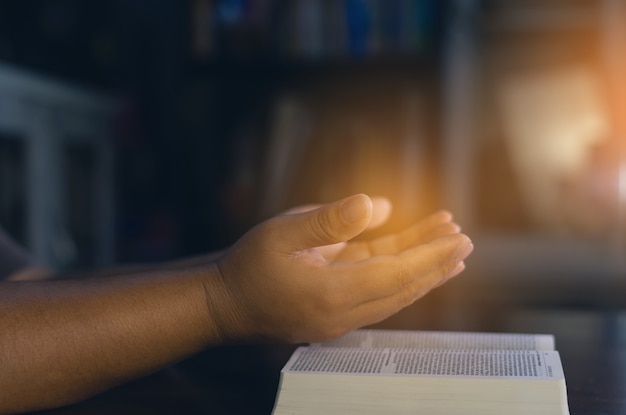 Christian hands while praying and worship for Jesus. christian people praying while hands worship over a Bible. learning religion.