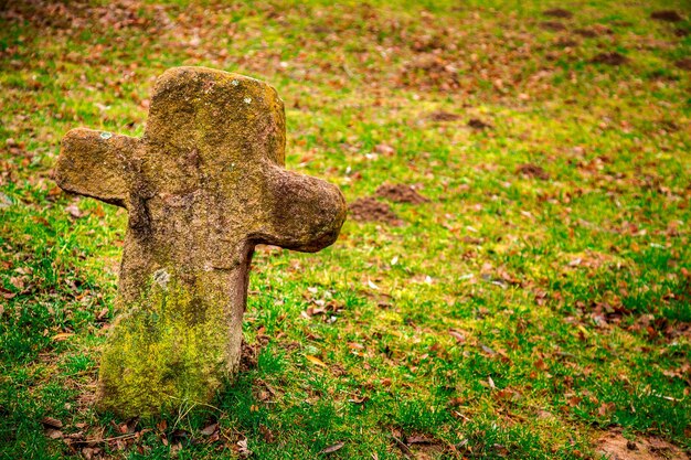 Christianity Religion Symbol Stone Cross in Cemetery and Grass