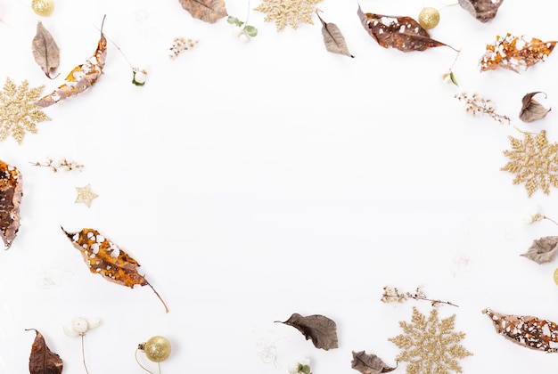 Christmas or autumn composition Dry autumn leaves and golden snowflakes Top view flat lay copy space