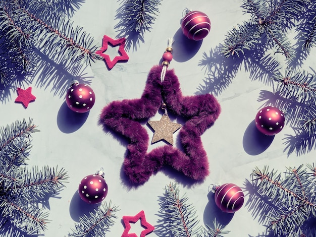 Christmas backdrop with fluffy fur star Xmas wreath and red bubble toys with polka dots Toned image green burgundy flat lay