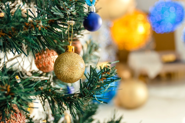 Christmas background - ball on the Christmas tree branch in soft-focus in the background.