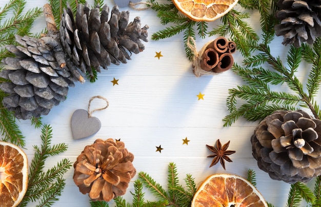 Christmas background Christmas tree branches pine cones cinnamon star anise orange chips on a white background with space for text Layout of a postcard poster