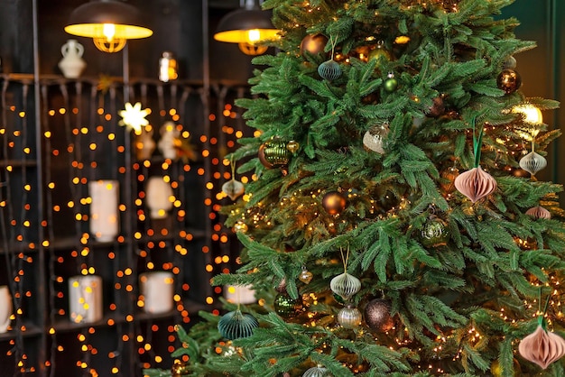 Christmas background Christmas tree decorated with festive balls toys and magic lights against the backdrop of blurry bokeh lights and loft style pendant lamps Soft selective focus