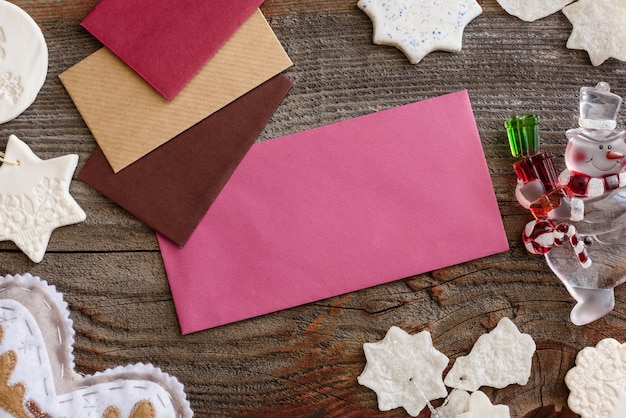 Photo christmas background concept. multicolored envelopes. christmas tree branches with cones.